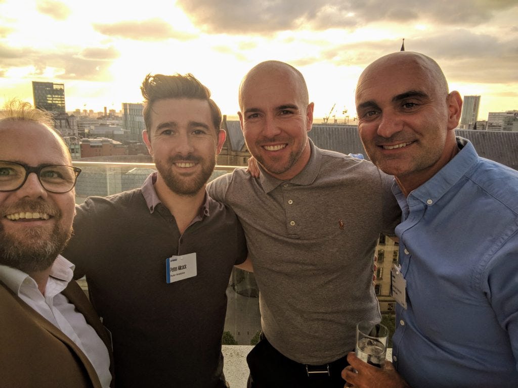Richard Gregory with three colleagues at a rooftop networking event at sunset